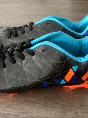 Brand New! Classic Black Kids Soccer Cleats with Bright Blue and Orange Accents